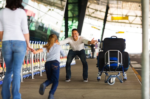 excited little girl running to her father at airport after a long wait with mother